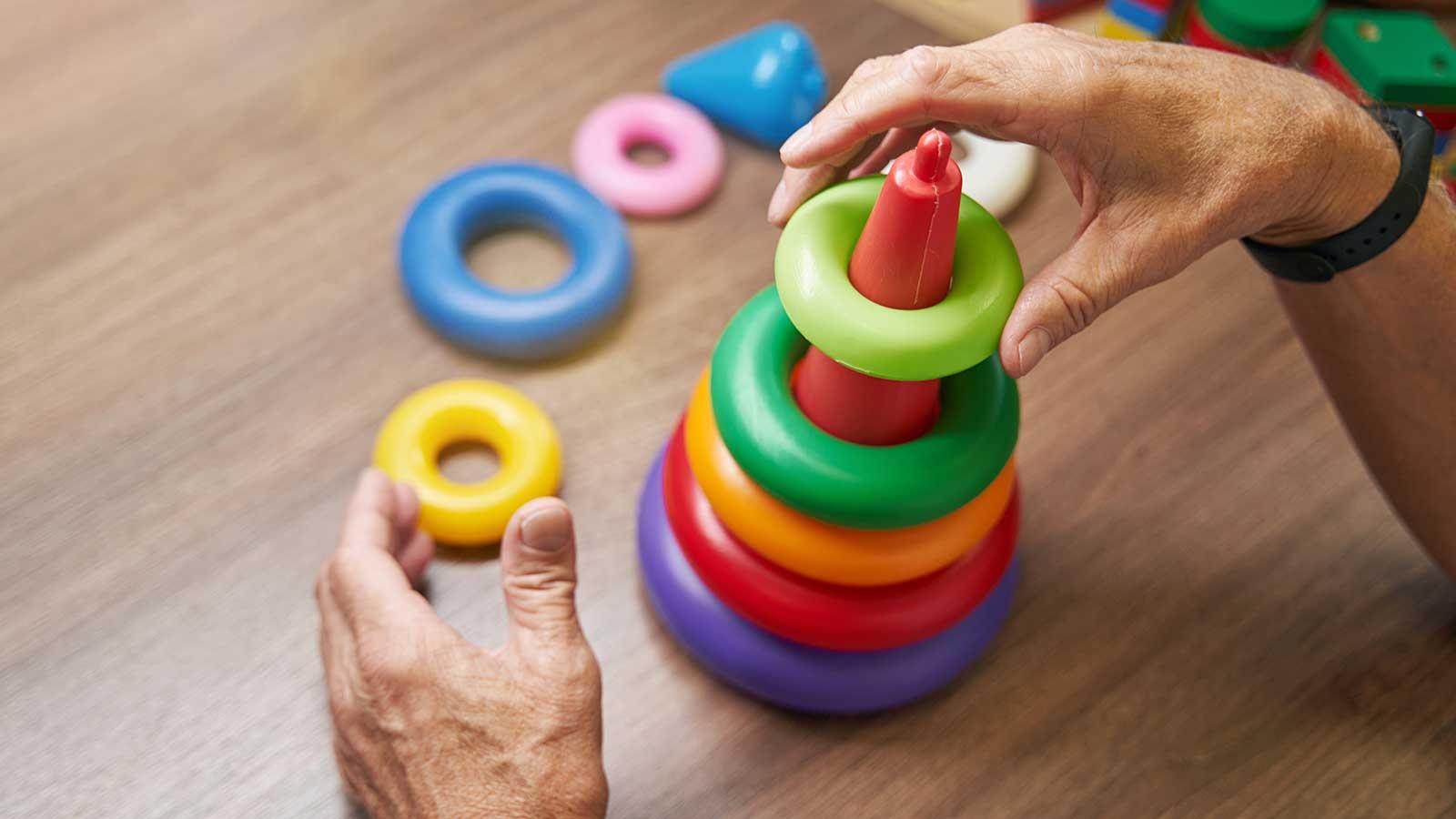 Person organizing colored plastic rings representing occupational therapy program at Clarkson university